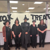 Circulation staff dressed up as witches. From left to right, library assistant Jaime, library assistant Cheryl, library assistant Bernice, circulation supervisor Laurie, and library assistant Donna