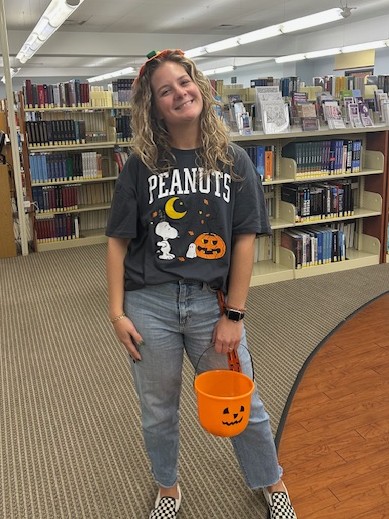 Senior Library Assistant Jace, in a Peanuts Halloween t-shirt featuring Snoopy