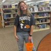 Senior Library Assistant Jace, in a Peanuts Halloween t-shirt featuring Snoopy