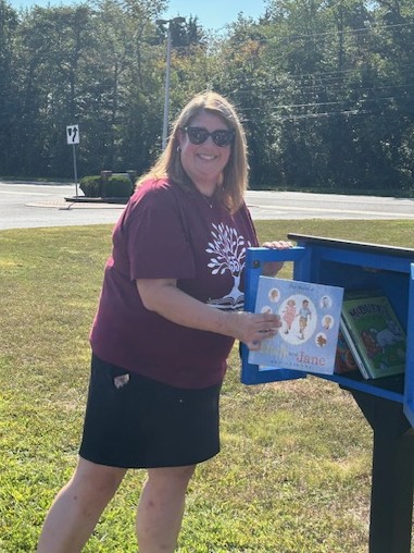 A book is placed in the new Little Free Library at Bells Elementary