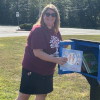 A book is placed in the new Little Free Library at Bells Elementary