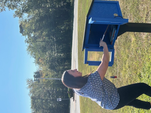 A book is placed in the new Little Free Library at Bells Elementary