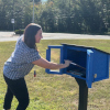 A book is placed in the new Little Free Library at Bells Elementary