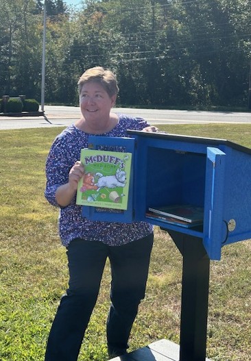 A book is placed in the new Little Free Library at Bells Elementary