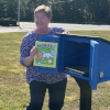 A book is placed in the new Little Free Library at Bells Elementary