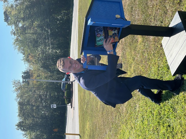 A book is placed in the new Little Free Library at Bells Elementary