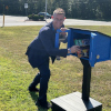 A book is placed in the new Little Free Library at Bells Elementary