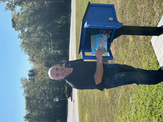 A book is placed in the new Little Free Library at Bells Elementary