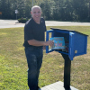 A book is placed in the new Little Free Library at Bells Elementary